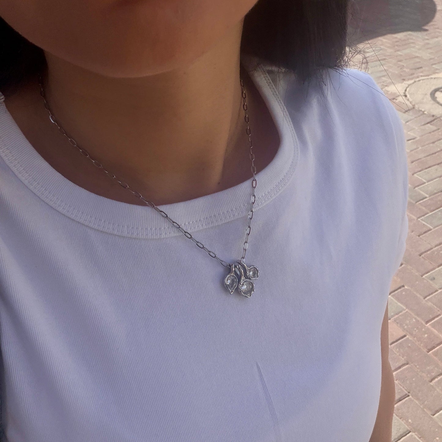 תקריב של תליון שרשרת LUMA עם אבנים נוצצות