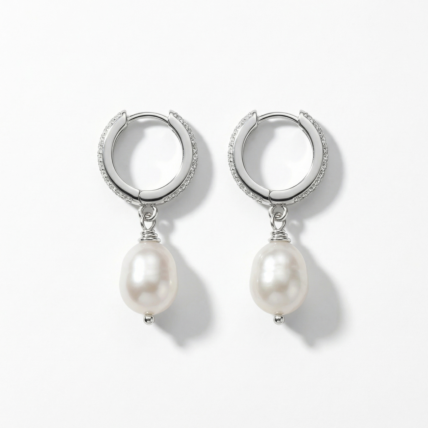 תקריב של עגילי כסף משובצים זרקונים עם פנינה אמיתית