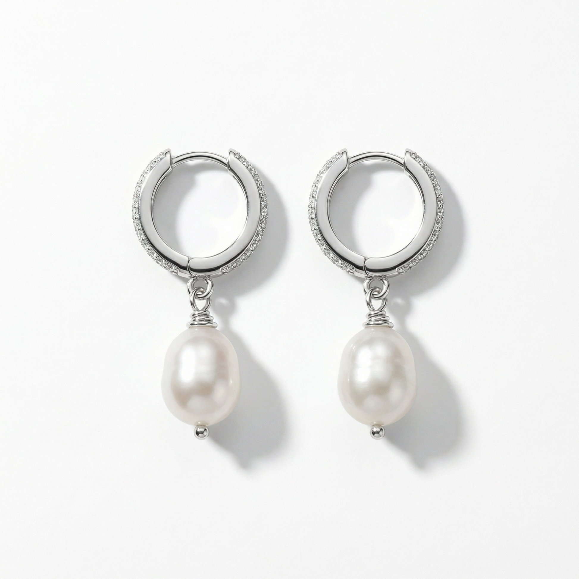 תקריב של עגילי כסף משובצים זרקונים עם פנינה אמיתית