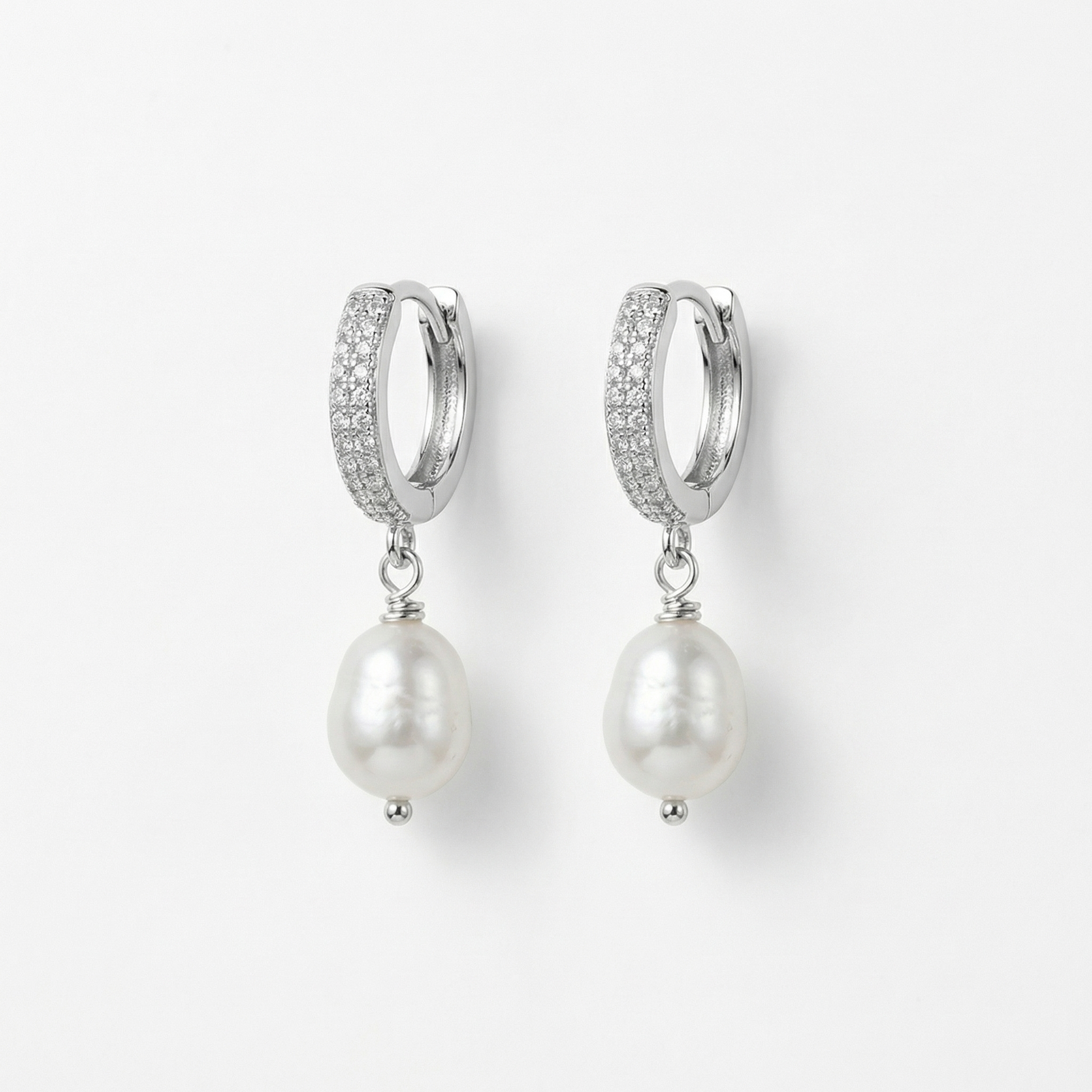 עגילי כסף עם פנינה תלויה בצילום קרוב